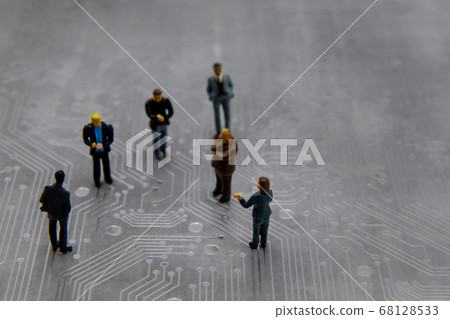 Miniature figurines posed as business people in a 68128533