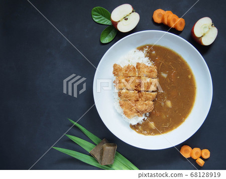 Japanese fried fish curry rice on white plate with ingredients on dirty dark background. Top view. Asian food concept. Japanese fried fish curry rice on white plate with ingredients on dirty dark background. Top view. Asian food concept. 68128919