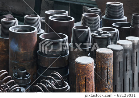 industrial background - rusty hardware, parts of turbodrills of various diameters are in the workshop industrial background - rusty hardware, parts of turbodrills of various diameters are in the workshop 68129031