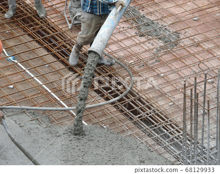 KUALA LUMPUR, MALAYSIA -SEPTEMBER 24, 2017: Construction workers puoring wet concrete using hose from the elephant crane or concrete pump crane at the construction site. 68129933