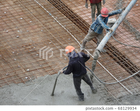KUALA LUMPUR, MALAYSIA -SEPTEMBER 24, 2017: Construction workers puoring wet concrete using hose from the elephant crane or concrete pump crane at the construction site. 68129934