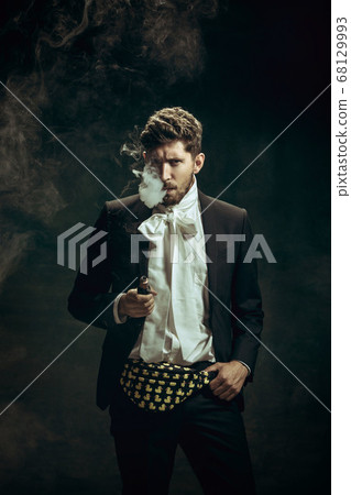 Young man as Dorian Gray on dark background. Retro style, comparison of eras concept. 68129993