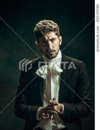 Young man as Dorian Gray on dark background. Retro style, comparison of eras concept. Young man as Dorian Gray on dark background. Retro style, comparison of eras concept. 68130090