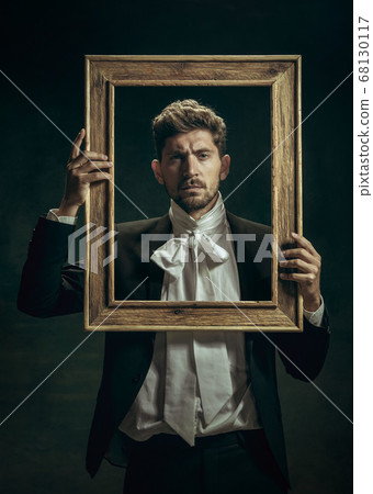 Young man as Dorian Gray on dark background. Retro style, comparison of eras concept. Young man as Dorian Gray on dark background. Retro style, comparison of eras concept. 68130117