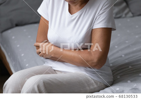 Elderly woman woke up suffers from abdominal pain 68130533