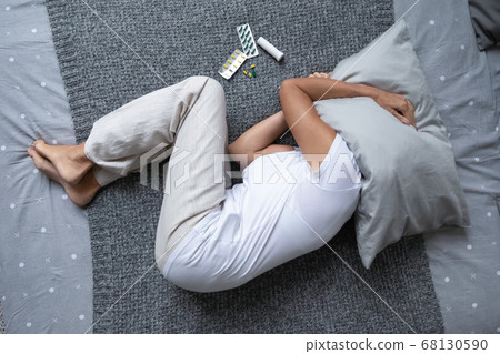 Desperate elderly woman lying in bed cover head with pillow 68130590