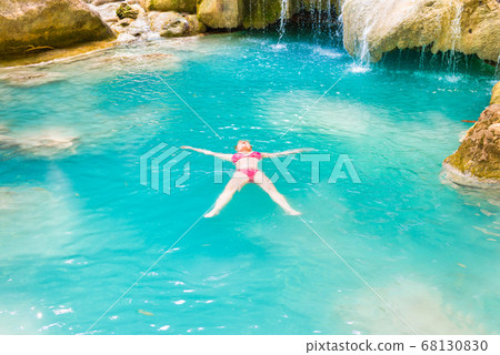 Young woman swims in emerald blue lake, Erawan Young woman swims in emerald blue lake, Erawan 68130830