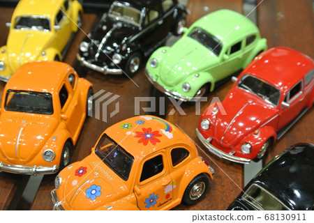 KUALA LUMPUR, MALAYSIA -DECEMBER 16, 2016: Miniature model of Volkswagen Beetle on wood texture board background. KUALA LUMPUR, MALAYSIA -DECEMBER 16, 2016: Miniature model of Volkswagen Beetle on wood texture board background. 68130911