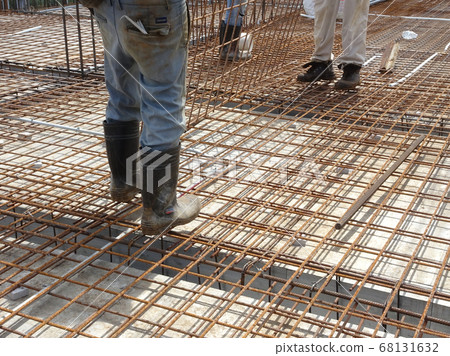KUALA LUMPUR, MALAYSIA -SEPTEMBER 23, 2017: Construction workers wearing safety shoes standing on the floor slab reinforcement bar at the construction site.  68131632
