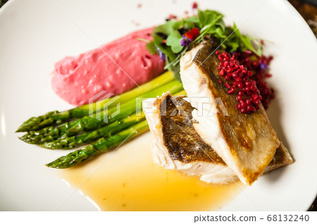 Pike-perch fillet. Asparagus, pearl couscous, white wine sauce, beet-flavored mashed potatoes. Delicious seafood fish closeup served on a table for lunch in modern cuisine gourmet restaurant 68132240
