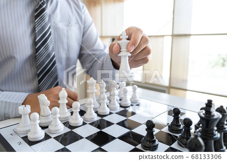 Businessman playing chess and thinking strategy Businessman playing chess and thinking strategy 68133306