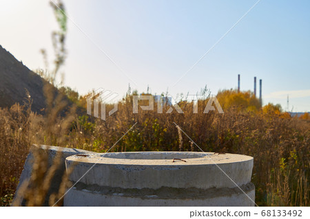 Close-up of a concrete well in the grass Close-up of a concrete well in the grass 68133492