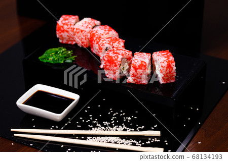 Sushi with salmon. Soy sauce, red caviar. Sushi on a black background. 68134193