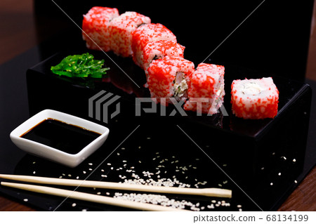 Sushi with salmon. Soy sauce, red caviar. Sushi on a black background. Sushi with salmon. Soy sauce, red caviar. Sushi on a black background. 68134199