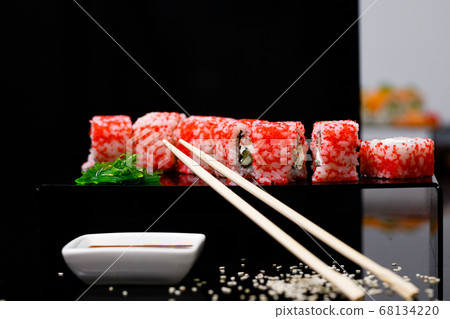 Sushi with salmon. Soy sauce, red caviar. Sushi on a black background. Sushi with salmon. Soy sauce, red caviar. Sushi on a black background. 68134220