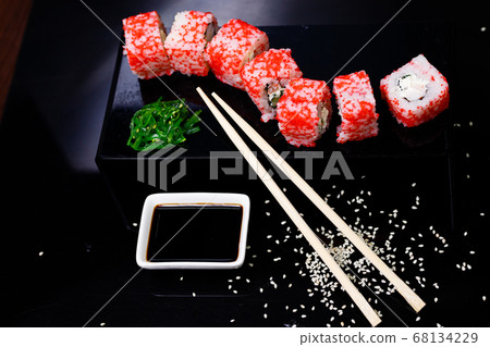 Sushi with salmon. Soy sauce, red caviar. Sushi on a black background. Sushi with salmon. Soy sauce, red caviar. Sushi on a black background. 68134229