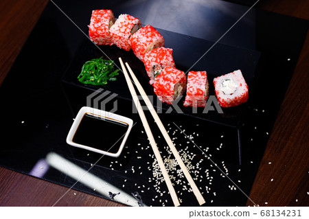 Sushi with salmon. Soy sauce, red caviar. Sushi on a black background. Sushi with salmon. Soy sauce, red caviar. Sushi on a black background. 68134231