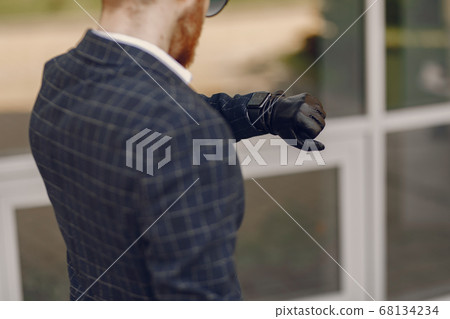 Businessman with suitcase walking in a summer city 68134234