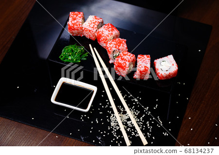 Sushi with salmon. Soy sauce, red caviar. Sushi on a black background. Sushi with salmon. Soy sauce, red caviar. Sushi on a black background. 68134237