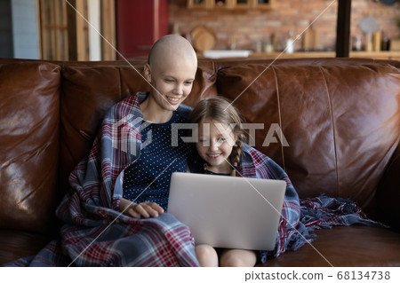 Happy sick young mother and little daughter using computer 68134738
