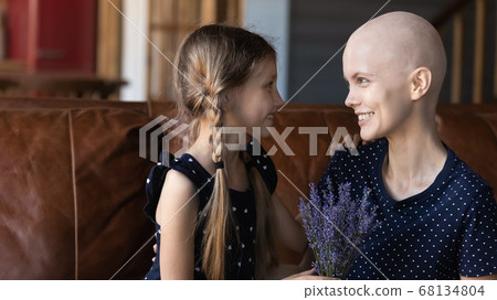 Loving little daughter greeting sick young mom 68134804