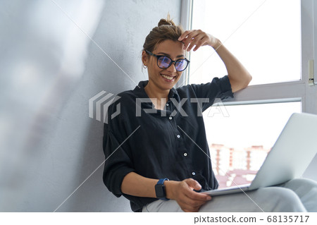Cheerful attractive woman with laptop at home 68135717