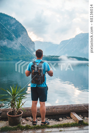 man with backpack looking at hallstatt sea man with backpack looking at hallstatt sea 68136014