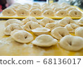 Homemade Dumplings lie on the baking tray in rows 68136017