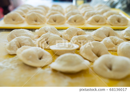 Homemade Dumplings lie on the baking tray in rows Homemade Dumplings lie on the baking tray in rows 68136017