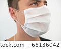 White protective mask on the young guy's face, portrait 68136042