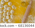 Homemade Dumplings lie on the baking tray in rows with rolling pin for dough 68136044