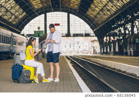 couple waiting for train at railroad station couple waiting for train at railroad station 68136045