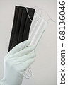 Man holds rubber gloves black and white face masks 68136046