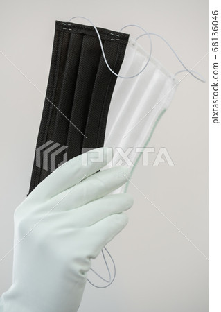 Man holds rubber gloves black and white face masks Man holds rubber gloves black and white face masks 68136046