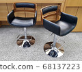 There are two pretty chairs in the office. 68137223
