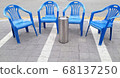There is a chair for relaxation on the side of the road. 68137250