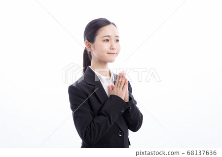 一起看用手的衣服的一名女性辦公室工作者 一起看用手的衣服的一名女性辦公室工作者 68137636