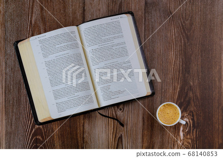 Open Bible morning readings on a table top with 68140853