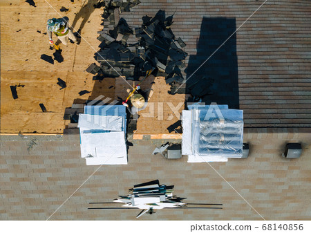 Construction worker on a replacement shingles roof Construction worker on a replacement shingles roof 68140856