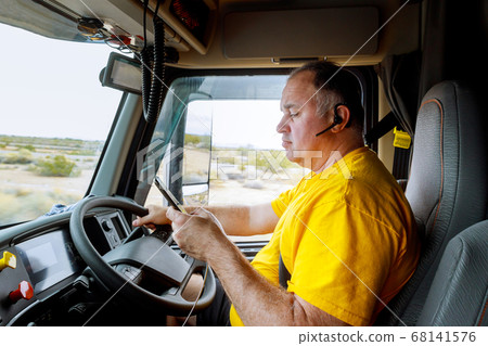 Driver on cabin on highway of smartphone in hand Driver on cabin on highway of smartphone in hand 68141576