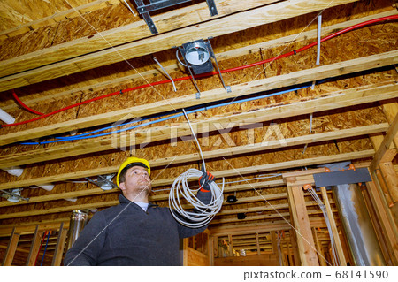 Electrician working with wires in new home Electrician working with wires in new home 68141590