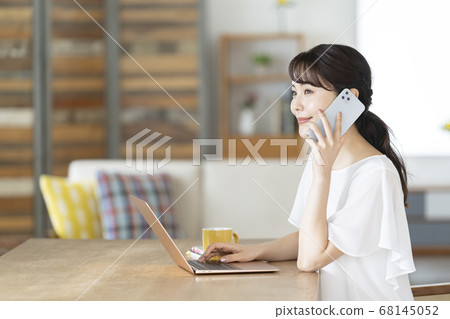 A young woman talking on a smartphone 68145052