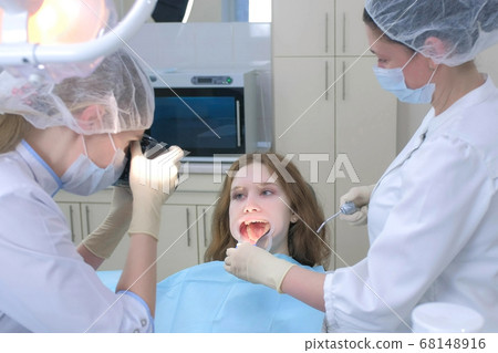 Dentist orthodontist photographing using camera girl teeth showing it in mirror. Dentist orthodontist photographing using camera girl teeth showing it in mirror. 68148916