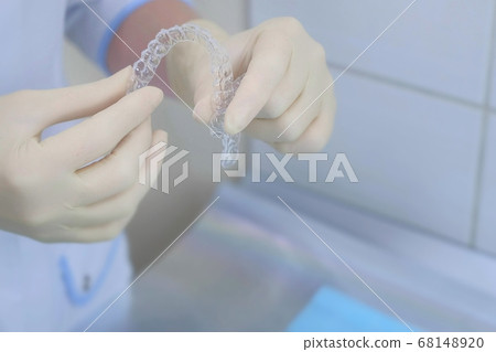 Silicone invisible transparent braces in orthodontist doctor hands in dentistry. 68148920