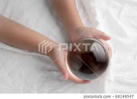 Hand holding a crystal glass ball transparent on 68149547