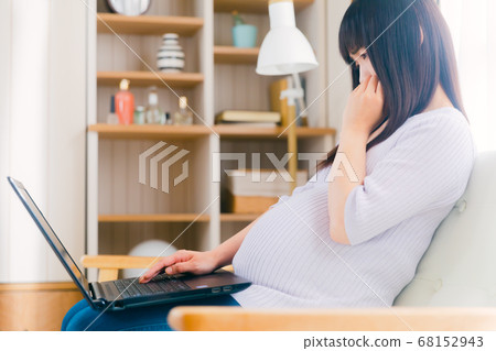 Pregnant woman operating a PC Thinking, troubled, confused Pregnant woman operating a PC Thinking, troubled, confused 68152943