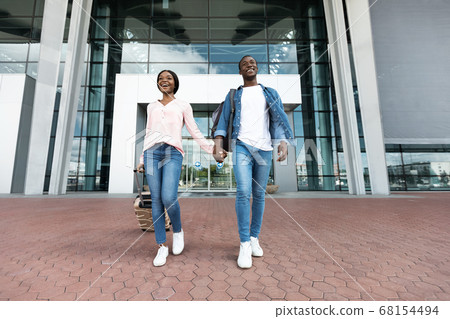 Ready For Adventures. Excited Black Couple Leaving Airport Building In New Country Ready For Adventures. Excited Black Couple Leaving Airport Building In New Country 68154494