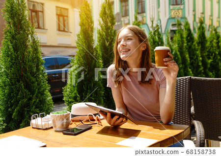 young woman using tablet pc in a cafe on a summer terrace 68158738