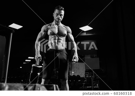 Muscular man carrying sledgehammer in gym. Muscular man carrying sledgehammer in gym. 68160318
