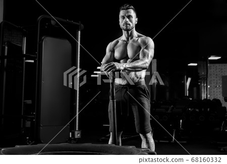 Monochrome portrait of man holding sledgehammer. 68160332